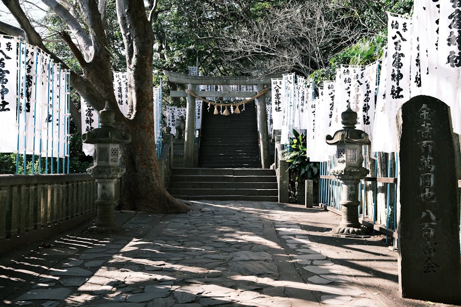 A tranquil path leading to a Shinto temple in Gamagōri, Aichi, Japan, lined with lanterns and banners.