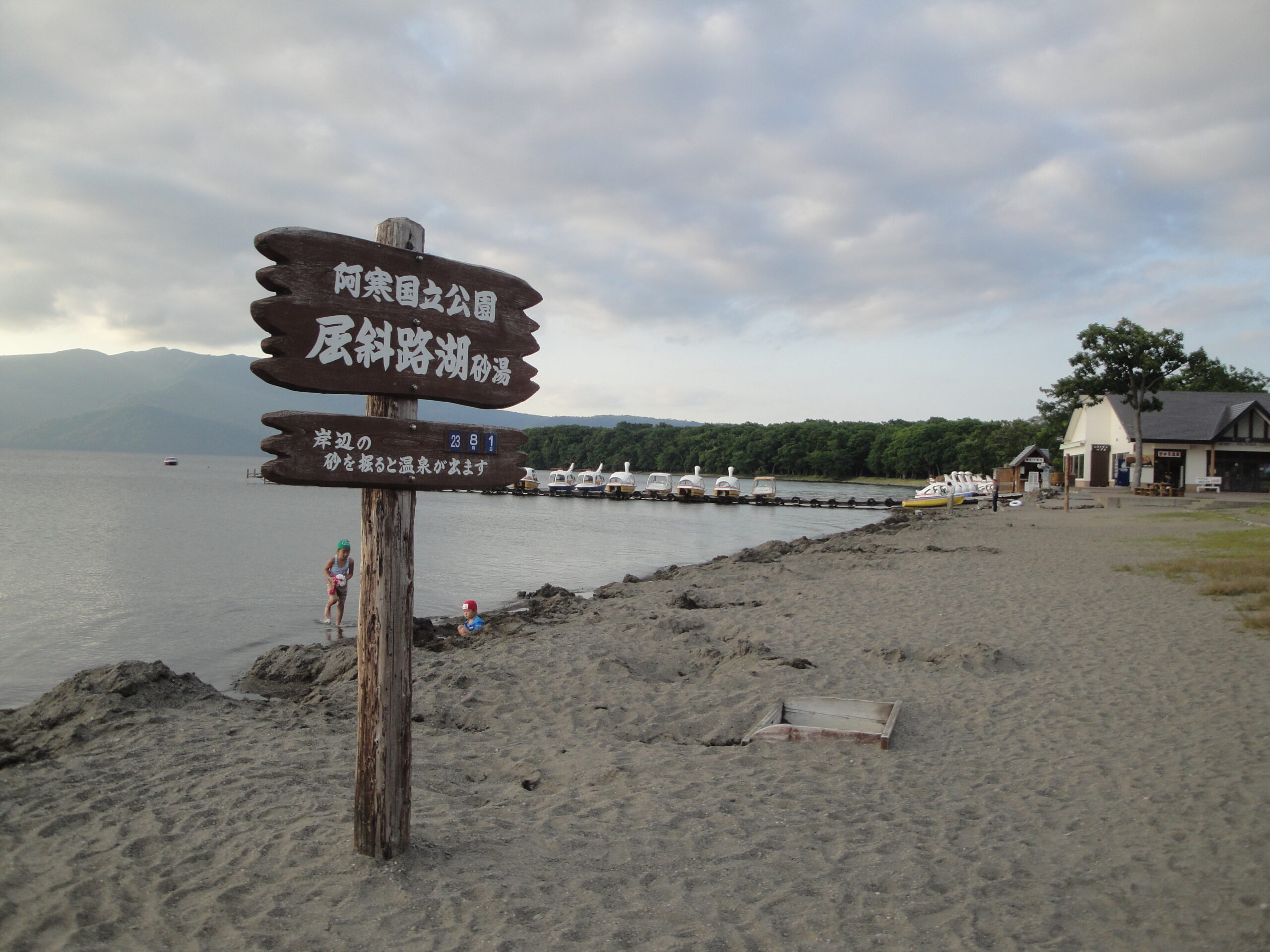 砂湯と「岸辺の砂を掘ると温泉が出ます」の看板