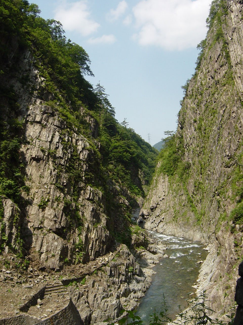 夏の清津峡。柱状節理の岩壁が両岸にそびえ、清流が流れる